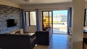 a living room with a couch and a fireplace with a view at Coquette villa avec piscine in Flic-en-Flac