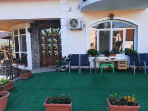 a patio with green grass and blue chairs and a door at Panoramic Apartment in Târgu-Mureş