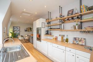a kitchen with white cabinets and wooden shelves at Vibrant City Centre Living in Aberdeen