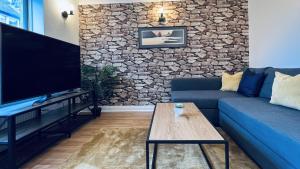 a living room with a blue couch and a stone wall at ☆ The Cottage - Cosy 1 bedroom, central location ☆ in Harrogate