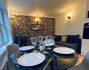 a dining table with plates and wine glasses on it at ☆ The Cottage - Cosy 1 bedroom, central location ☆ in Harrogate
