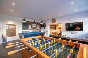 a living room with a pool table and a tv at Welsh Row House in Llandegla