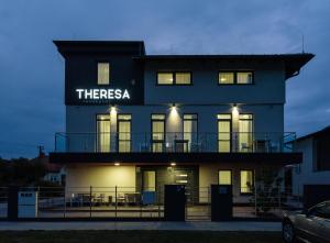 een zwart gebouw met een bord dat daarop staat bij Theresa Vendégház in Kiskunmajsa