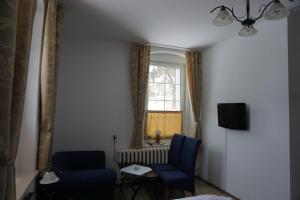 ein Wohnzimmer mit 2 Stühlen und einem Fenster in der Unterkunft Willa Dunajec in Kudowa-Zdrój