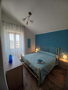um quarto com uma cama e uma parede azul em L'Acero di STALL em Viterbo