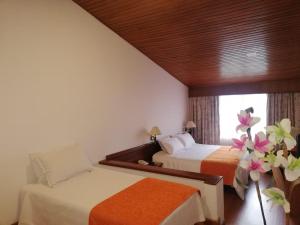 a hotel room with two beds and a window at Daza Hotel in Paipa