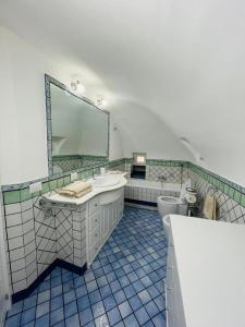 bagno con lavandino, servizi igienici e specchio di La Casetta di Sasá a Procida