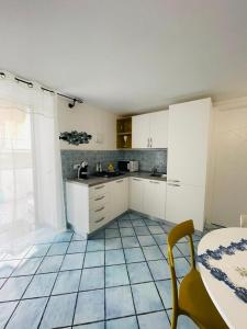 a kitchen with white cabinets and a tiled floor at La Casetta di Sasá in Procida