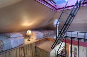 Zimmer mit 2 Betten, einer Lampe und einer Leiter in der Unterkunft Hilltop House in Creede