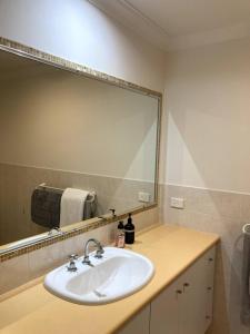 La salle de bains est pourvue d'un lavabo et d'un grand miroir. dans l'établissement Modern 2 Bedroom Apartment in Perth, à Perth