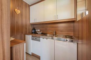 a kitchen with white cabinets and a sink at Gästeheim Krößbach in Neustift im Stubaital