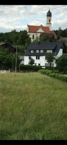 a white building with a clock tower in a field at ruhige drei Zimmer Eigentumswohnung 