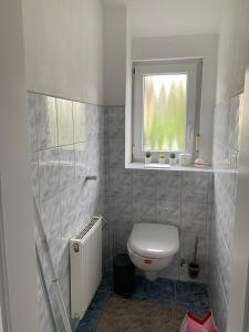 La salle de bains est pourvue de toilettes et d'une fenêtre. dans l'établissement ruhige drei Zimmer Eigentumswohnung, 