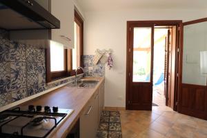 a kitchen with a sink and a stove top oven at casa Vincenzo in Castelluzzo