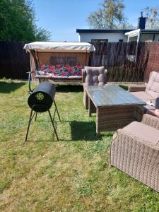 een barbecue in de achtertuin met een tafel en stoelen bij Apartament Charzykowy ''Biała Flaga'' in Charzykowy