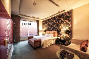 中レキ区にある中壢峇里島汽車旅館のベッドとソファ付きのホテルルーム