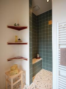 a bathroom with a shower with green tiles at Rûte - Bed no Breakfast in Bruges