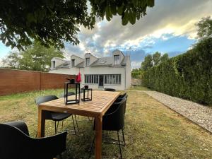 einen Tisch mit Stühlen vor einem Haus in der Unterkunft Maison de campagne entièrement climatisée avec grand jardin in Pressagny l'Orgueilleux