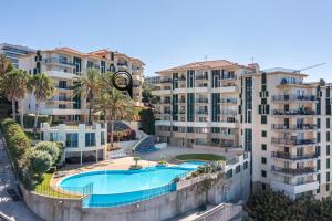 an apartment with a swimming pool and apartment buildings at Atlantic Ocean View Apartment in Funchal