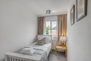 a small bedroom with a bed and a window at Grove Avenue in Norwich