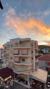 ヒマラにあるIonian Blue Apartamentの夕日を背景に見えるアパートメントビル