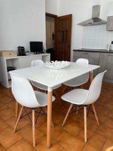 un tavolo bianco e sedie in cucina di Appartamento vicino Rho Fiera a Cornaredo