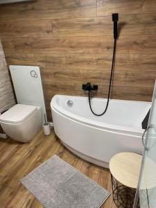 a bathroom with a white tub and a toilet at Tó Kincse Vendégház in Kustánszeg