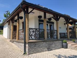 Casa con techo de madera y balcón en Tó Kincse Vendégház, en Kustánszeg