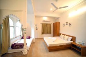 a bedroom with two beds and a window at Royal Heritage Haveli Udaipur in Udaipur