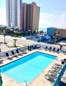 ein großer Pool mit Stühlen und ein Hotel in der Unterkunft Beachside Resort Hotel in Gulf Shores