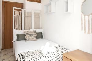 Un dormitorio con una cama blanca con una cruz. en Nazaré Downtown Flat, en Nazaré