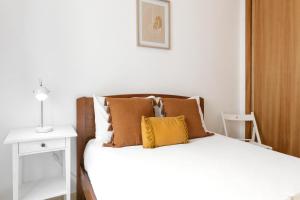 1 dormitorio con 1 cama con almohadas marrones en Nazaré Downtown Flat, en Nazaré