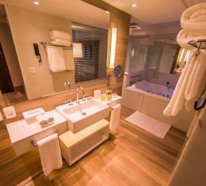 a bathroom with a large sink and a tub at Vogal Luxury Beach Hotel & SPA in Natal