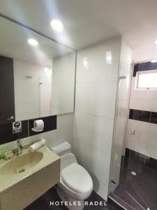 La salle de bains est pourvue de toilettes, d'un lavabo et d'une douche. dans l'établissement Hotel Radel Superior, à Bogotá