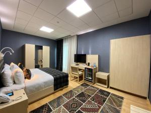 een hotelkamer met een bed en een bureau bij Badam d'Art Boutique Hotel in Baku