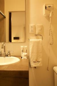 a bathroom with a sink and a mirror and a towel at Hotel Real Alma in Oaxaca City