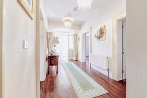 un corridoio di una casa con pareti bianche e pavimenti in legno di 2 Victoria Street ad Armagh