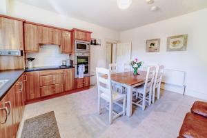 a kitchen with wooden cabinets and a wooden table and chairs at 2 Victoria Street in Armagh