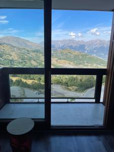een raam met uitzicht op een rivier en de bergen bij Studio au pied des pistes 4 pers, Alpes Le Corbier in Le Corbier