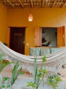 hamaca en una habitación del complejo con sofá en Pousada Coco Brasil, en Caraíva