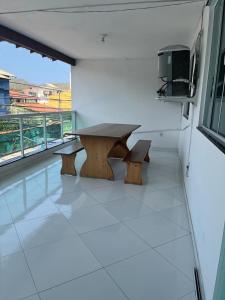 una mesa y dos bancos en una habitación con ventana en Hospedagem Central I, en Arraial do Cabo