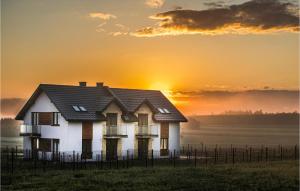 una casa con la puesta de sol en el fondo en Beautiful Apartment In Busko Zdroj With House A Panoramic View en Busko-Zdrój