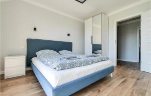 1 dormitorio con 1 cama grande y cabecero azul en Beautiful Apartment In Busko Zdroj With House A Panoramic View en Busko-Zdrój