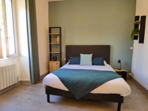 a bedroom with a large bed with blue pillows at Logis Hôtel Emeraude in Confolens