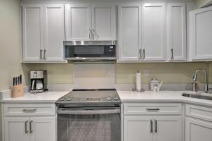a kitchen with white cabinets and a stove top oven at DC Guesthouse with Fire Pit 6 Mi to Ivy City! in Washington, D.C.