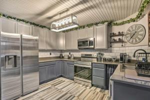 a kitchen with stainless steel appliances and a clock on the wall at Modern Central Apartment with BBQ Patio and Yard! in Central