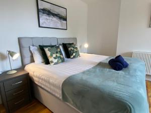 a bedroom with a large bed with a blue blanket at De Parys Premier Lodge 3 in Bedford in Bedford