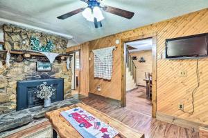 a living room with a fireplace and a ceiling fan at Rustic Cabin with Patio and Pond on Blue Ridge Parkway in Glade Valley