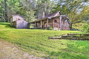 a large house on a grassy field with a house at Cozy Ennice Cabin on the Blue Ridge Parkway! in Glade Valley
