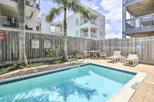 einen Pool in einem Garten mit einem Holzzaun in der Unterkunft South Padre Island Condo - 200 Ft to Beach! in South Padre Island